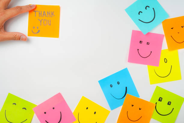istock Thank you and smile icon inspirational handwriting on sticky notes on hand held 2168016636