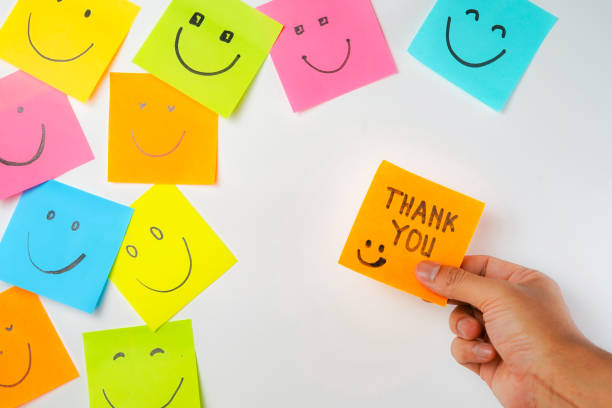 istock Thank you and smile icon inspirational handwriting on sticky notes on hand held 2168016691