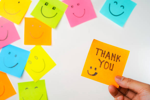 istock Thank you and smile icon inspirational handwriting on sticky notes on hand held 2168016724