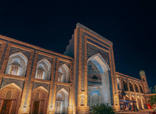 istock A large building with a blue and white facade is lit up at night. The building has a large archway and a balcony. The building is surrounded by trees and he is a historic site 2168018934
