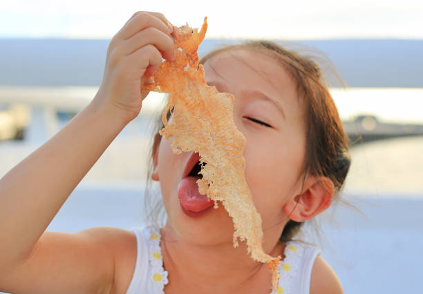 Adorable little girl eating Mashed squid.