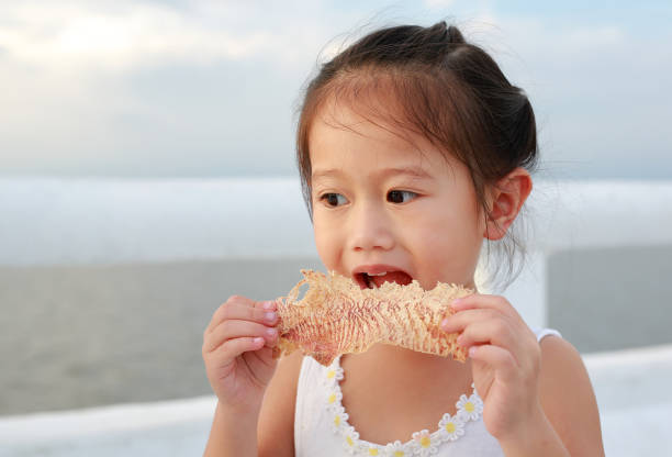 Adorable little girl eating Mashed squid.
