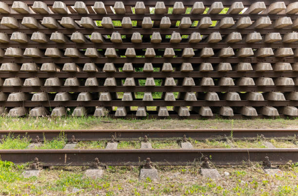 A large pile of stacked train tracks, creating an industrial and chaotic scene. The metal rails, intertwined and jumbled, evoke a sense of abandonment and the raw power of heavy machinery.