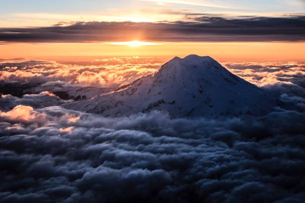 toma idílica del monte rainier entre nubes contra el cielo durante la puesta de sol - monte rainier fotografías e imágenes de stock