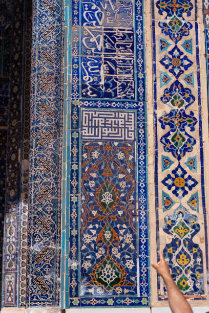 istock A blue and white tile wall with Arabic writing. A person is pointing at the wall 2168025650