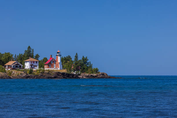 An old lighthouse along the rocky shore of Great Lake Superior during summer.