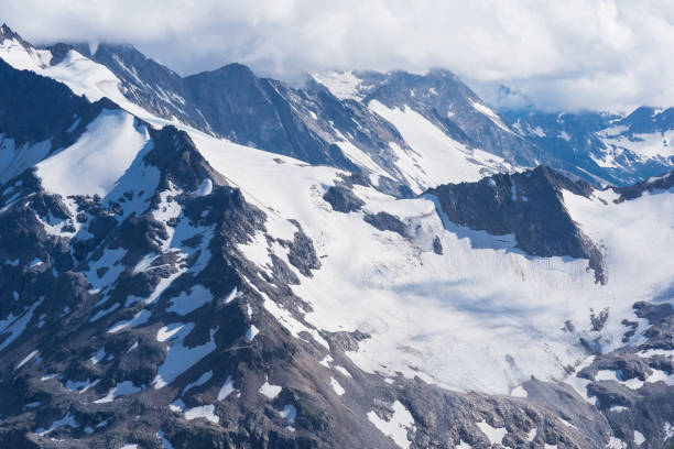 istock highlands landscape, mountain ranges with glaciers among clouds 2168027204
