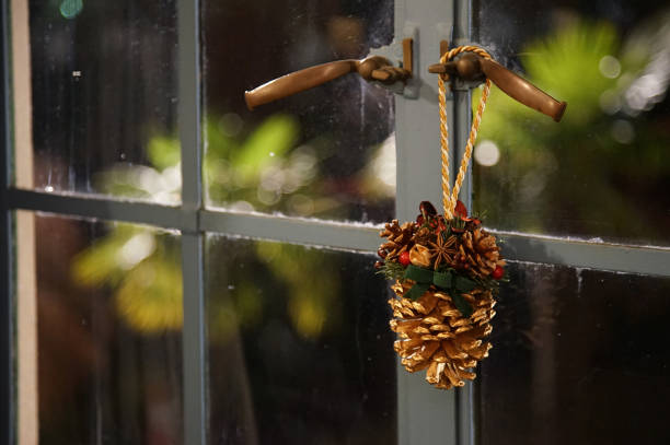 Pine cones decorated on the window handle of the room at night during the Christmas season