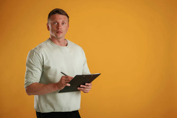 istock With notepad and pen. Man is against background in the studio 2168031013