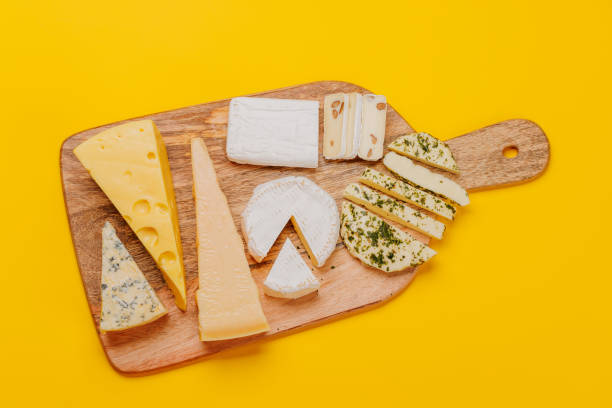 Top view of cheese and meat platter ingredients on wooden table. Preparation of delicious appetizer on kitchen table.