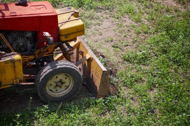 istock excavator removing tall green grass, clearing a construction site, old tractor removing green grass, preparing for construction, clearing a site, starting work, nature and machinery. 2168032010