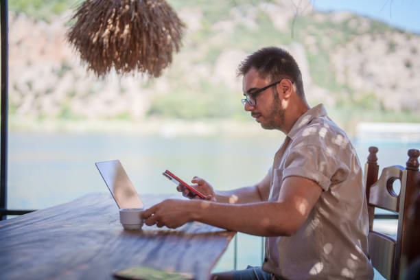 istock Tourist man on summer vacation, using laptop and smartphone 2168035802