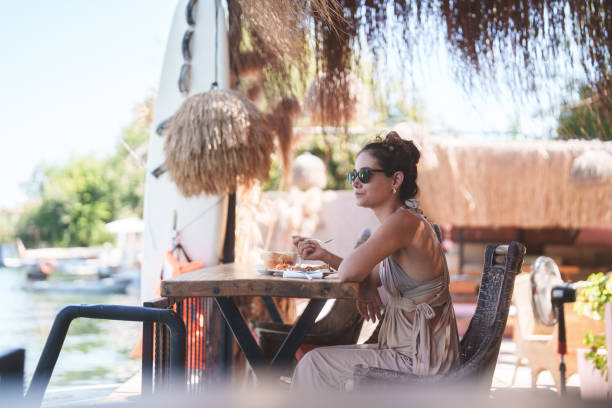 istock A woman on summer vacation having breakfast next to river. 2168040332