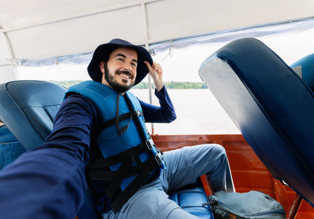 istock Young adventurer taking selfie while sailing on fast boat on the Amazon River 2168044687