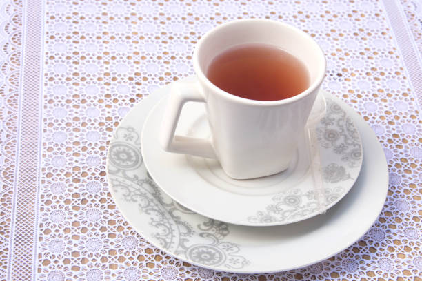 Cup of tea on a white lace tablecloth. Selective focus.