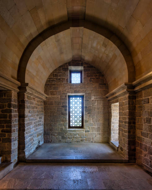 Historic stone chamber with arched ceiling and intricately patterned window in an ancient structure