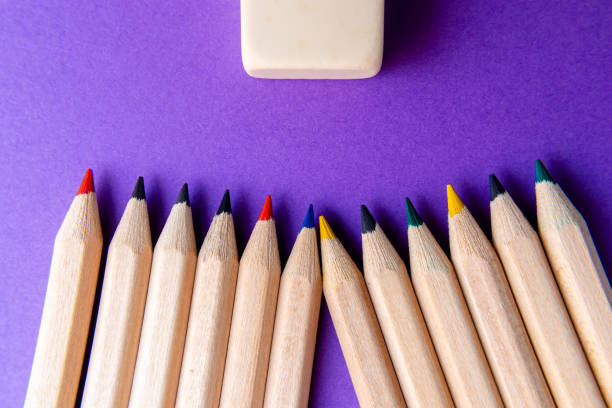 Colored multi-colored pencils on a purple background. back to school. Top view.