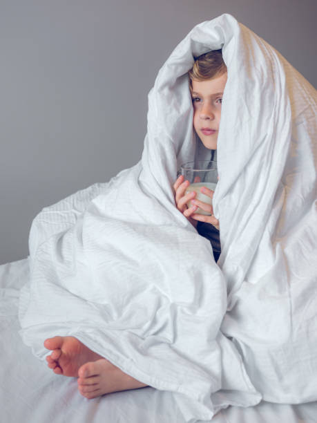 istock Little boy wrapped in blanket on bed 2168045745