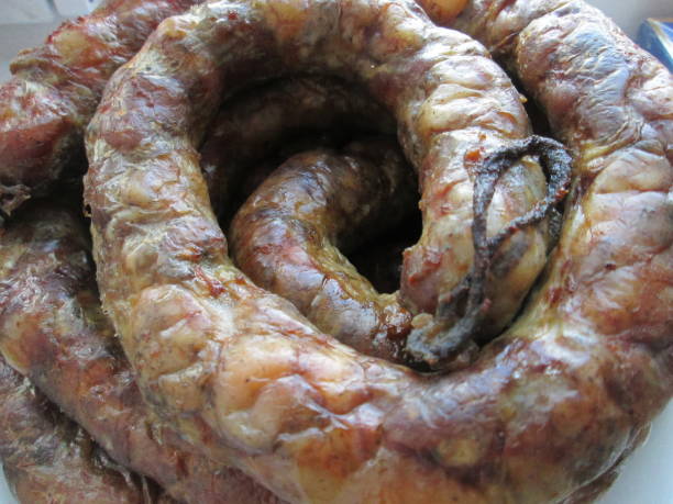 istock Juicy sausage coils glisten with seasoning, showcasing a rich, enticing appearance. These handmade delicacies are a culinary delight, perfect for a hearty meal. 2168047607
