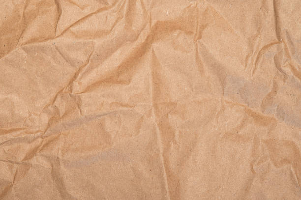istock Brown craft baking paper sheet top view background, parchment for baking culinary, piece of wrinkled or crumpled paper texture 2168048779