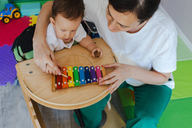 istock Sensory therapist guides a young boy with neurodevelopmental disorders in playing a colorful xylophone as part of his physical rehabilitation activity 2168049203