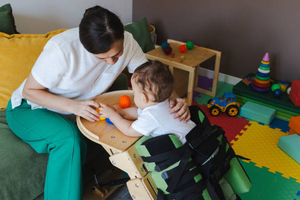 istock Little child with movement disorders standing in verticalizer during rehabilitation session with female physiotherapist to improve health 2168049245