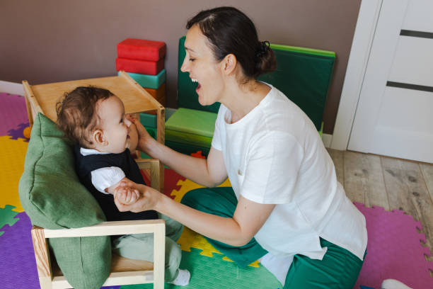 istock Young boy with coordination disorders is engaged in physical rehabilitation activities guided by caregiver in therapy space 2168049250