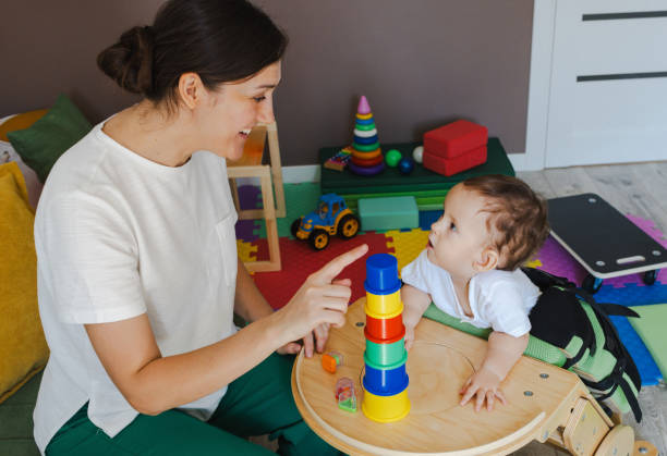 istock Mother together with her little boy with movement disorders spend useful time while child stands in the verticalizer. Home physiotherapy 2168049257