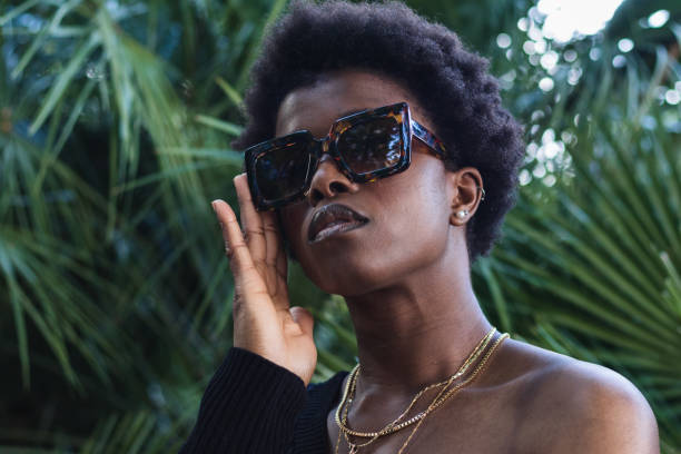istock Confident black woman in sunglasses against greenery 2168055773