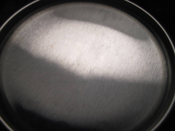 The polished metallic surface captures light in a soft interplay of reflections, showcasing smooth textures and gradients that convey a sense of sleek elegance and contemporary style.