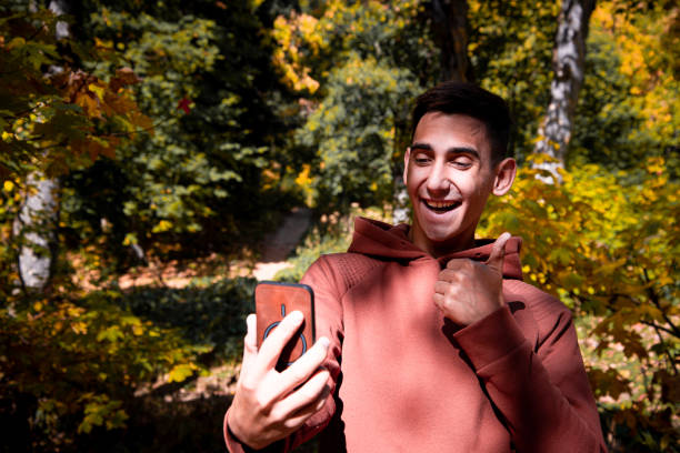 istock A young attractive guy is resting in the autumn forest. 2168059982