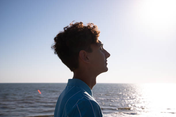 istock A young attractive guy is walking on the beach. 2168060063