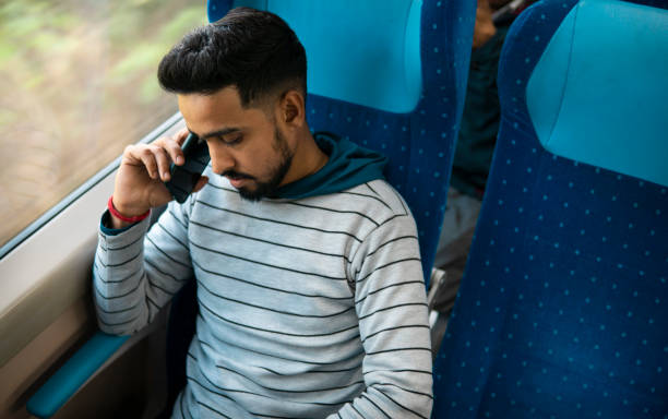 istock Indian young man talking on smartphone while traveling by the train. 2168060349
