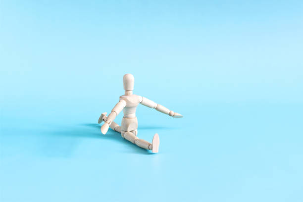 istock A wooden mannequin sits on the splits in close-up on a light background. 2168060718