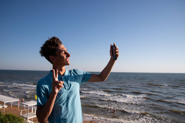 istock A young attractive guy is walking on the beach. 2168060741