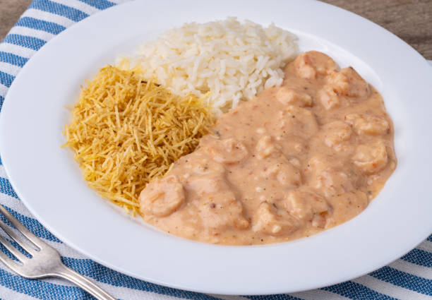 istock Shrimp strogonoff with rice and straw potato over wooden table 2168061303