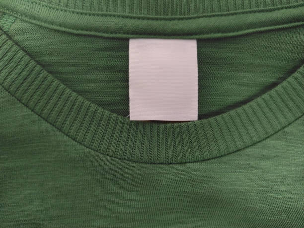 istock Blank white label indicating clothing size and washing instructions on green background of cotton t-shirt 2168066104
