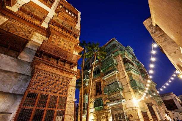 Low angle view at twilight of tower houses and rawashin aka mashrabiya enclosed with carved teak latticework designed to capture cool air and provide privacy.