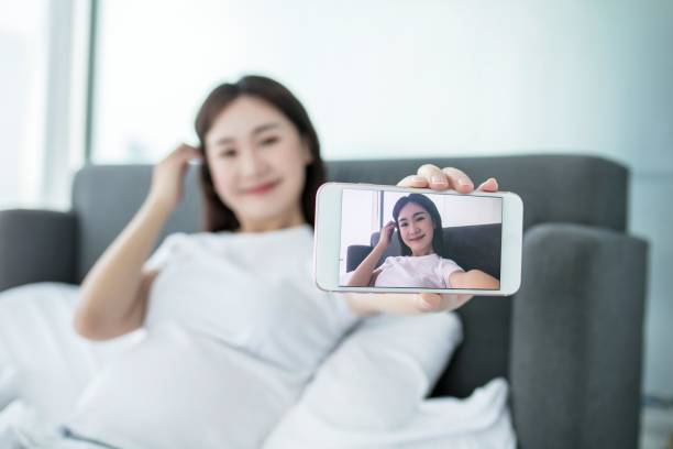 istock Asian woman taking selfie on bed 2168066934
