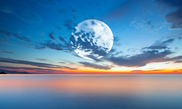 istock Full moon rising over the sea at sunset 2168068344