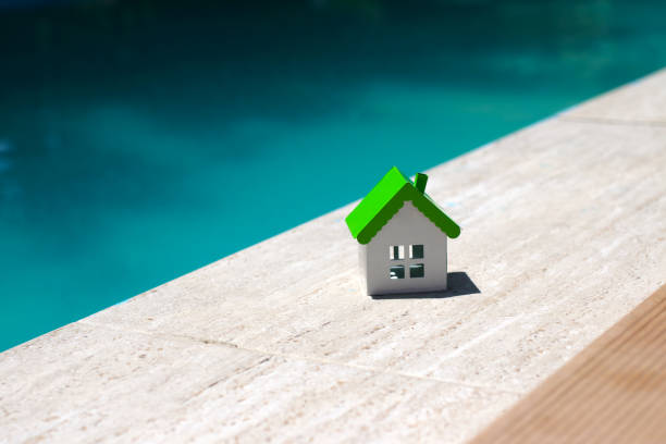 istock Miniature house on swimming pool edge 2168074861
