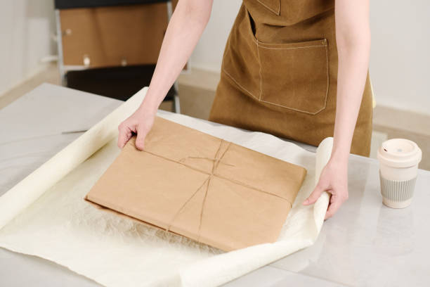 istock Hands of craftswoman packing parcel 2168076955