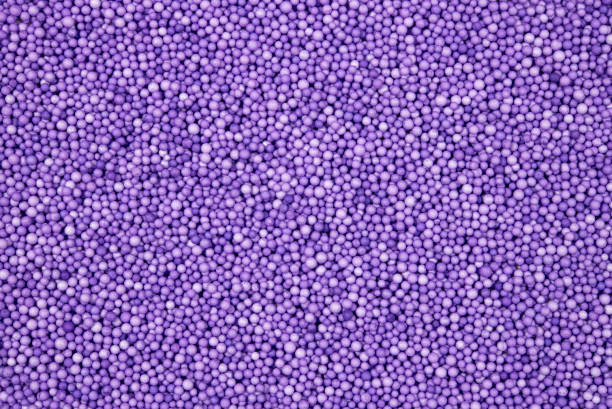 Detailed image showcasing a dense layer of small purple foam beads. Perfect for backgrounds, textures, and abstract compositions. Captures a sense of creativity and playfulness.