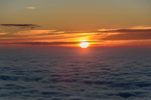 Photograph of a sunrise over a sea of ​​clouds.
