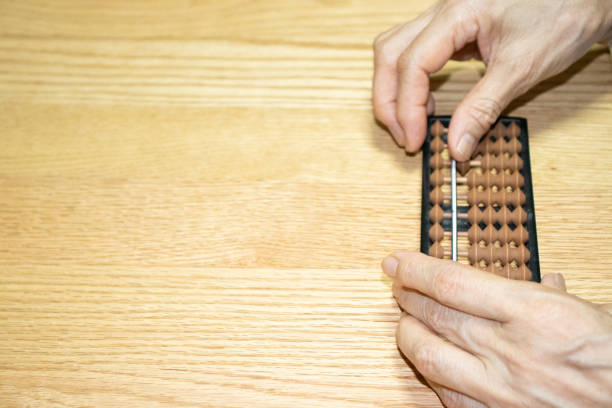 istock Senior woman's hand doing calculations on the abacus 2168078545