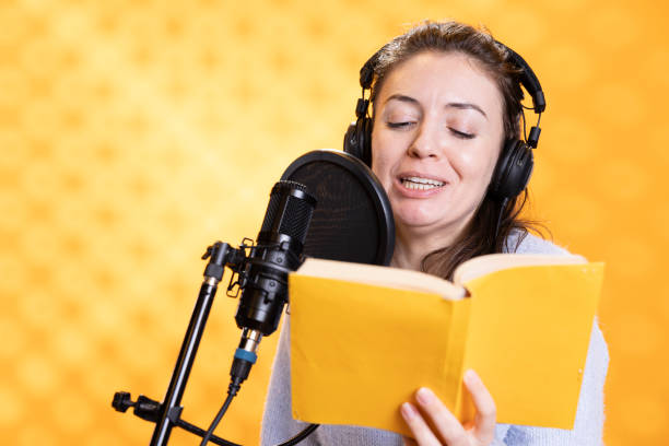 istock Smiling voice talent reading book, recording audiobook, studio background 2168079418