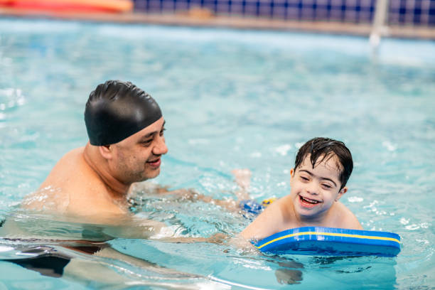 istock Father playing with son during swimming pool lessons 2168080313