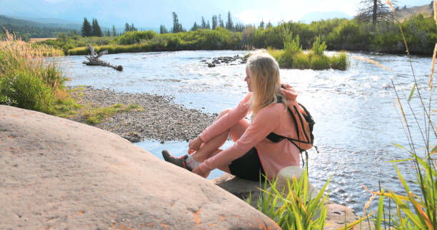 istock Mature woman explores river in mountains 2168080816