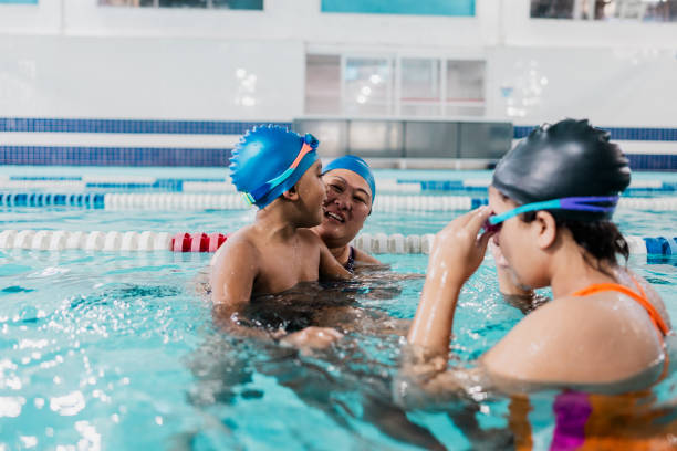 istock Instructor talking with children at swimming pool 2168081176