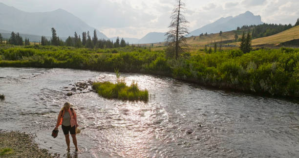 istock Mature woman explores river in mountains 2168083377